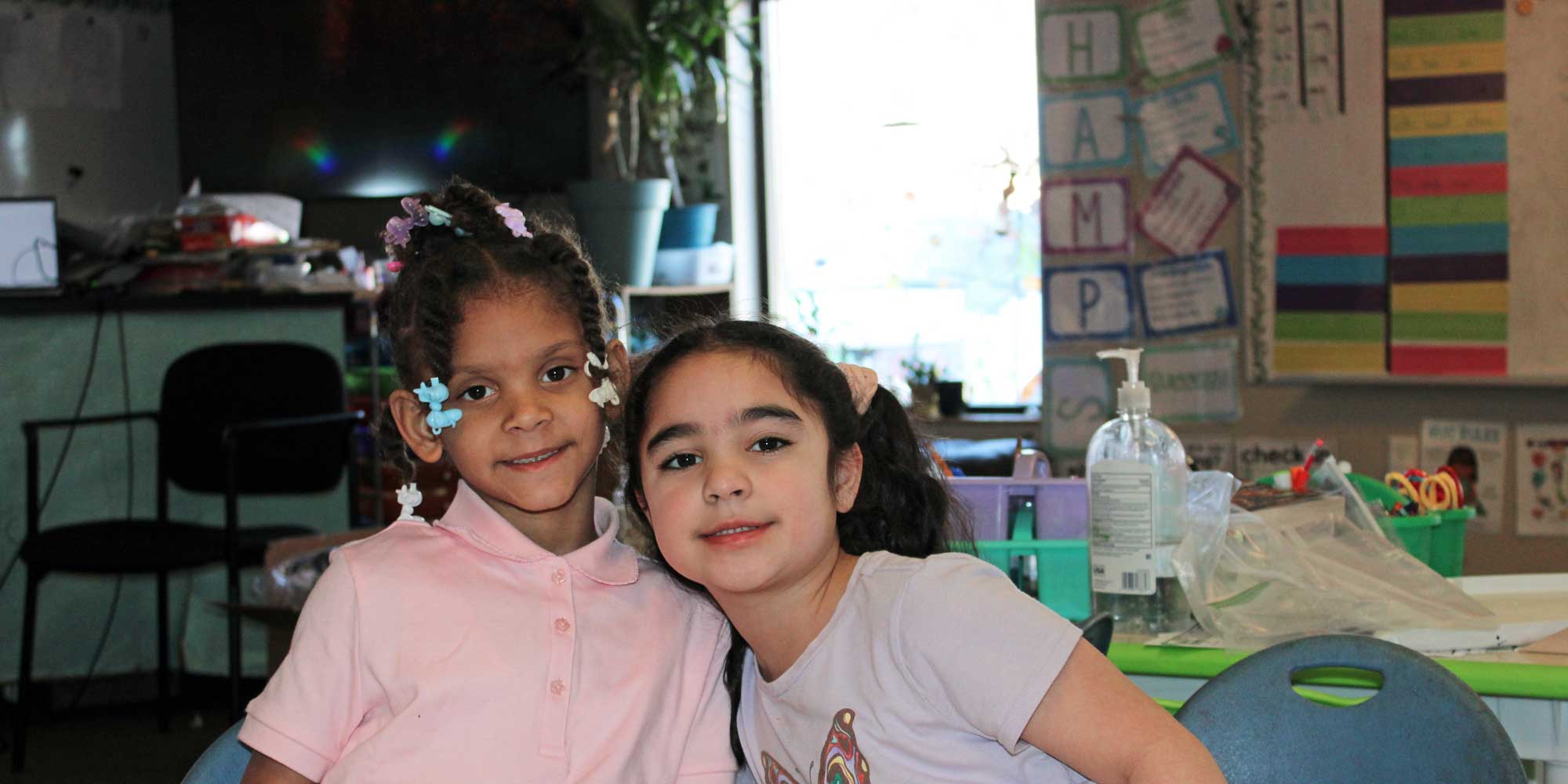 Two smiling students in a classroom.